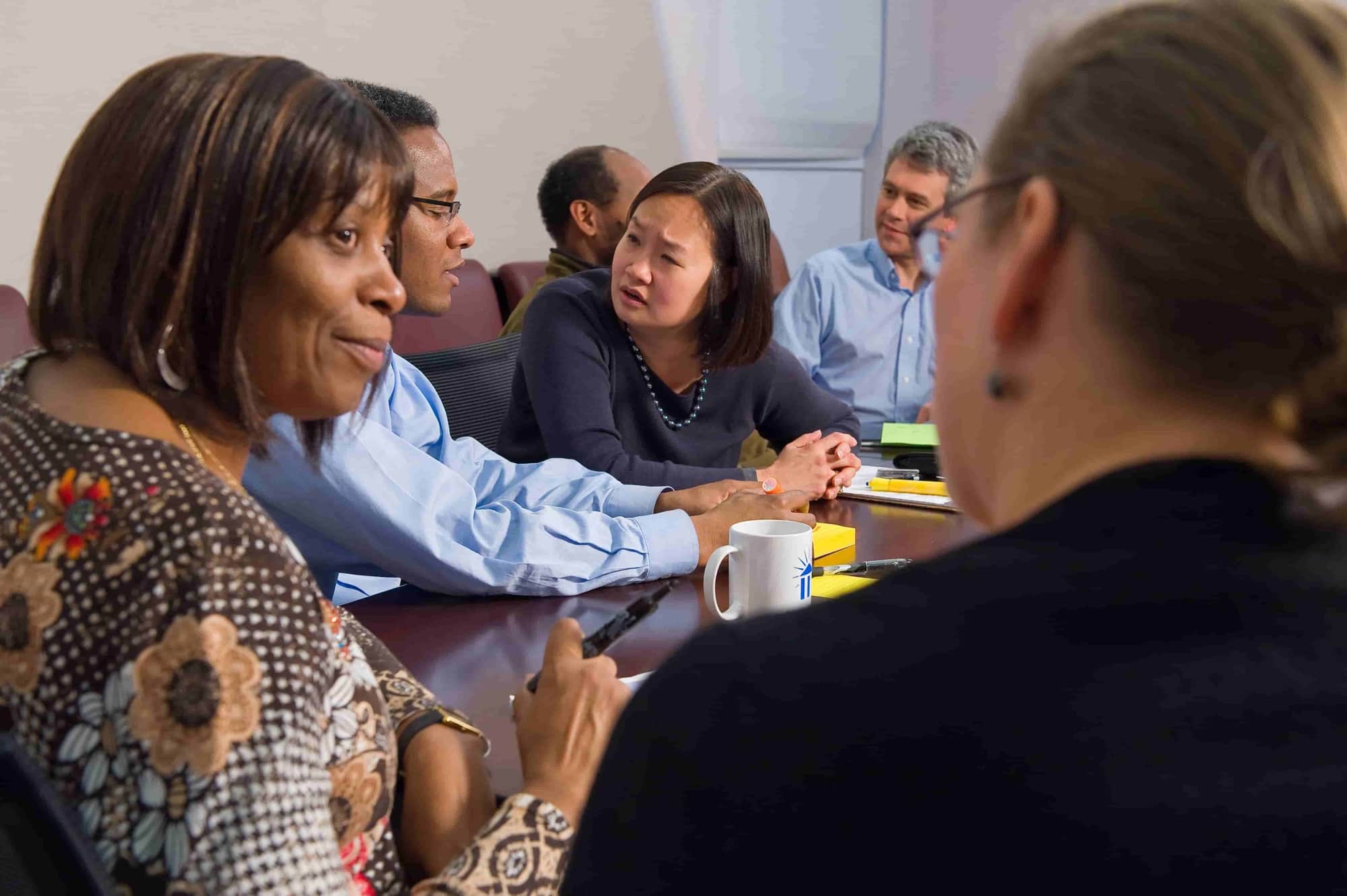 People talk with each other at a conference table