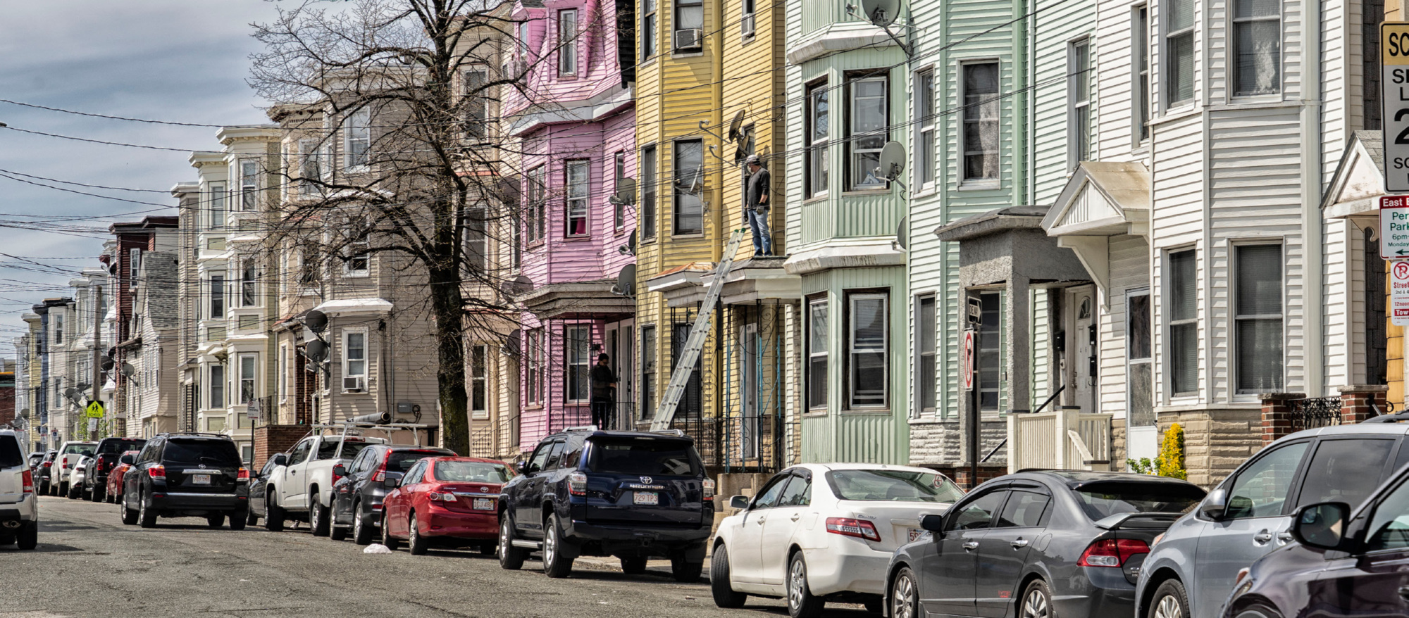 Neighborhood street with cars and multi-family homes