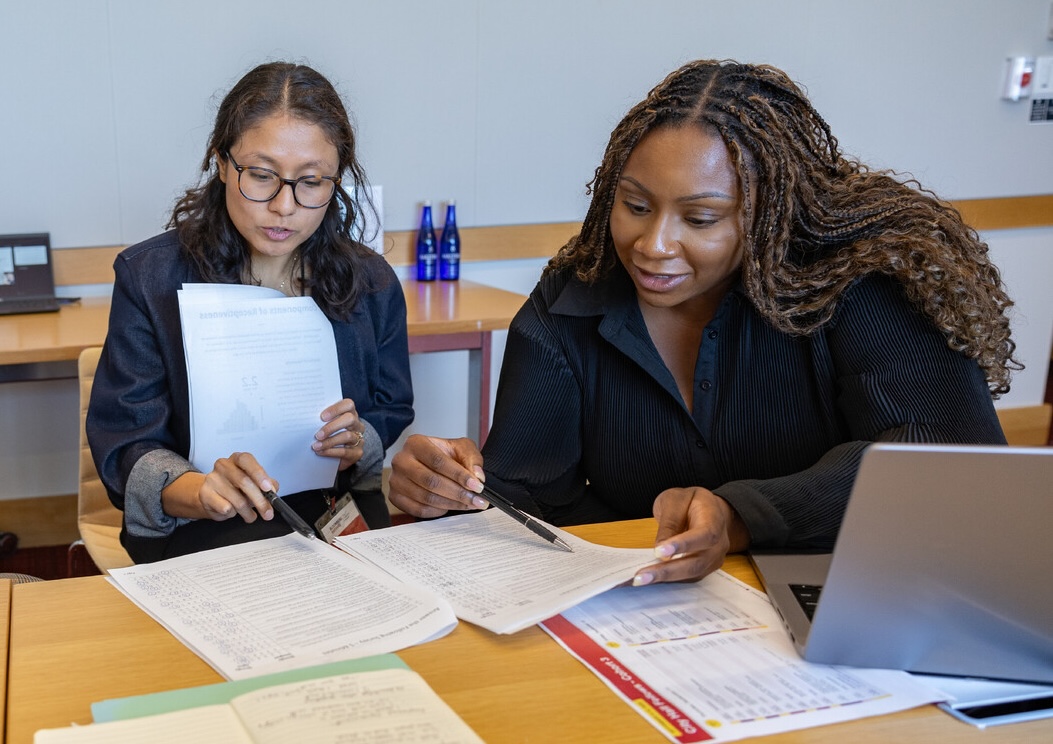 students looking over papers at a desk